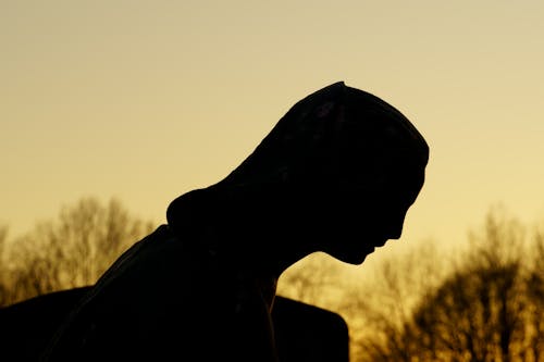 Silhouette of a woman in a cemetery at sunset