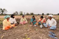 Group of Indian farmers sitting together sharing a meal in a rural field near Nagpur, India.