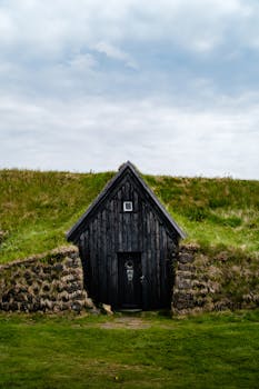 Explore the unique architecture of a traditional Keldur turf house set in Iceland's lush landscape.
