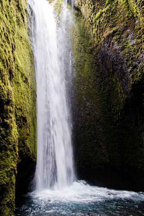 Free Stunning waterfall cascading through a mossy gorge, capturing the serene beauty of nature. Stock Photo