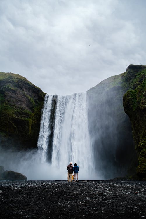 Couple Standing under Waterfall