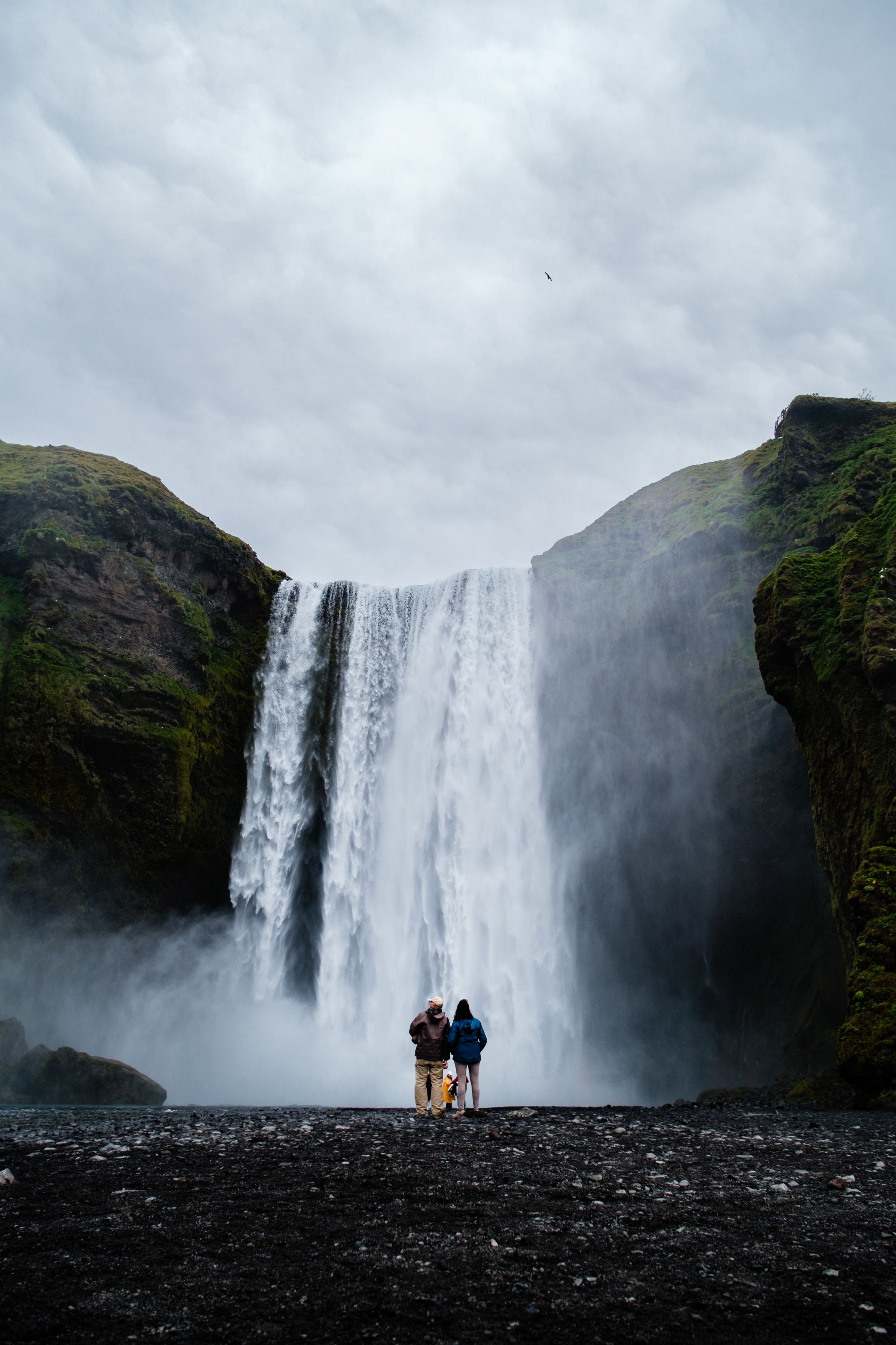 Two people standing in front of a waterfall · Free Stock Photo