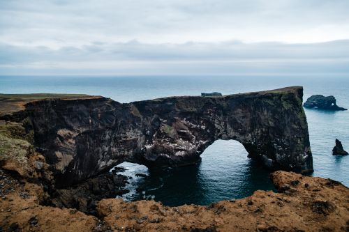 Free Stunning view of the Dyrhólaey natural arch in Iceland with rugged coastline and ocean backdrop. Stock Photo