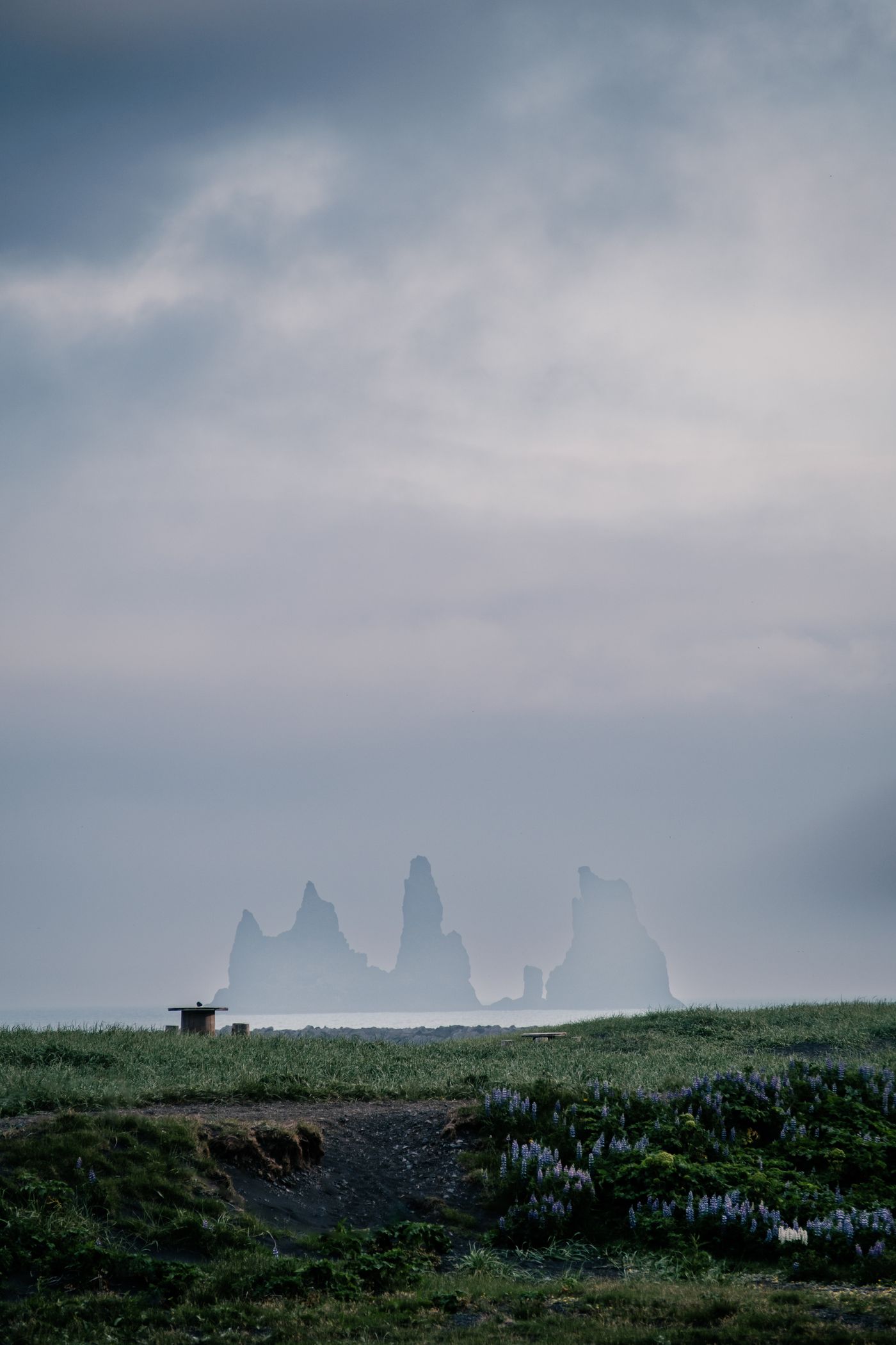 The Reynisdrangar basalt sea stacks in mist at Reynisfjara black sand beach, Iceland