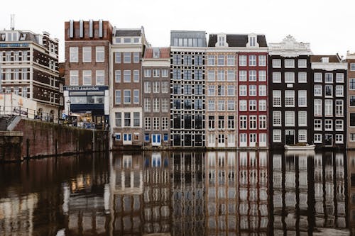 A row of buildings with reflections in the water