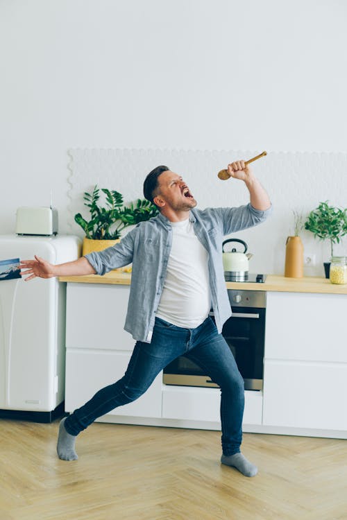 Man in Shirt Singing with Spoon in Kitchen