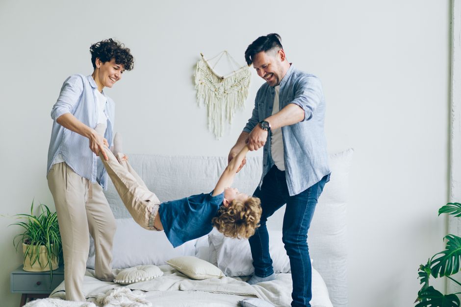 Photo by Vitaly Gariev on Pexels Joyful family playing with their son on a bed in a modern and bright bedroom setting. - Photo by Vitaly Gariev on Pexels