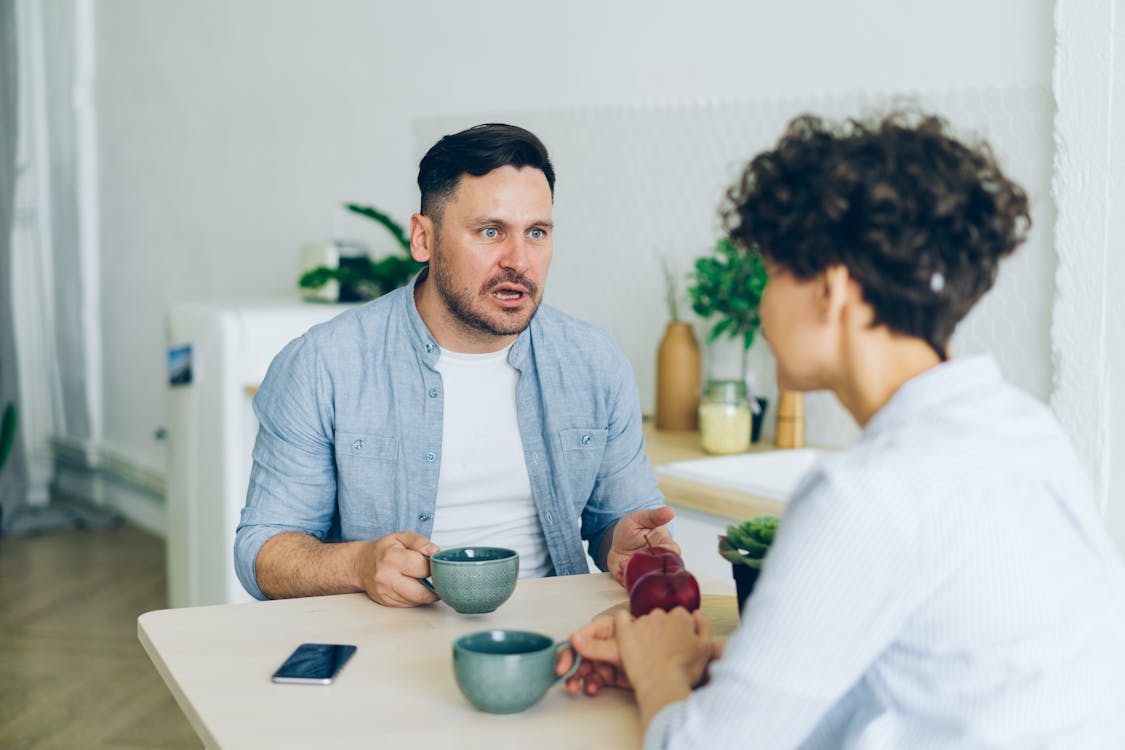 Free A Couple Sitting at a Table at Breakfast and Arguing Stock Photo