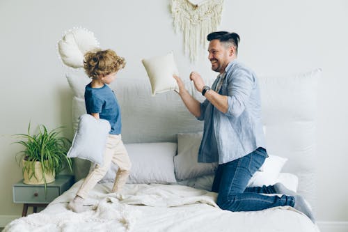 Father and His Little Son Having a Pillow Fight 