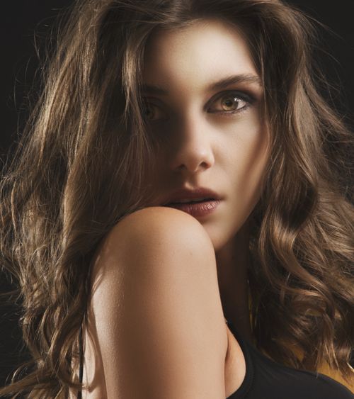 Free Close-up portrait of a young woman with captivating eyes and curly hair. Stock Photo