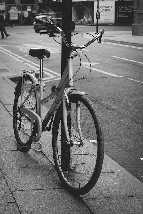 A bicycle leaning against a pole on a street