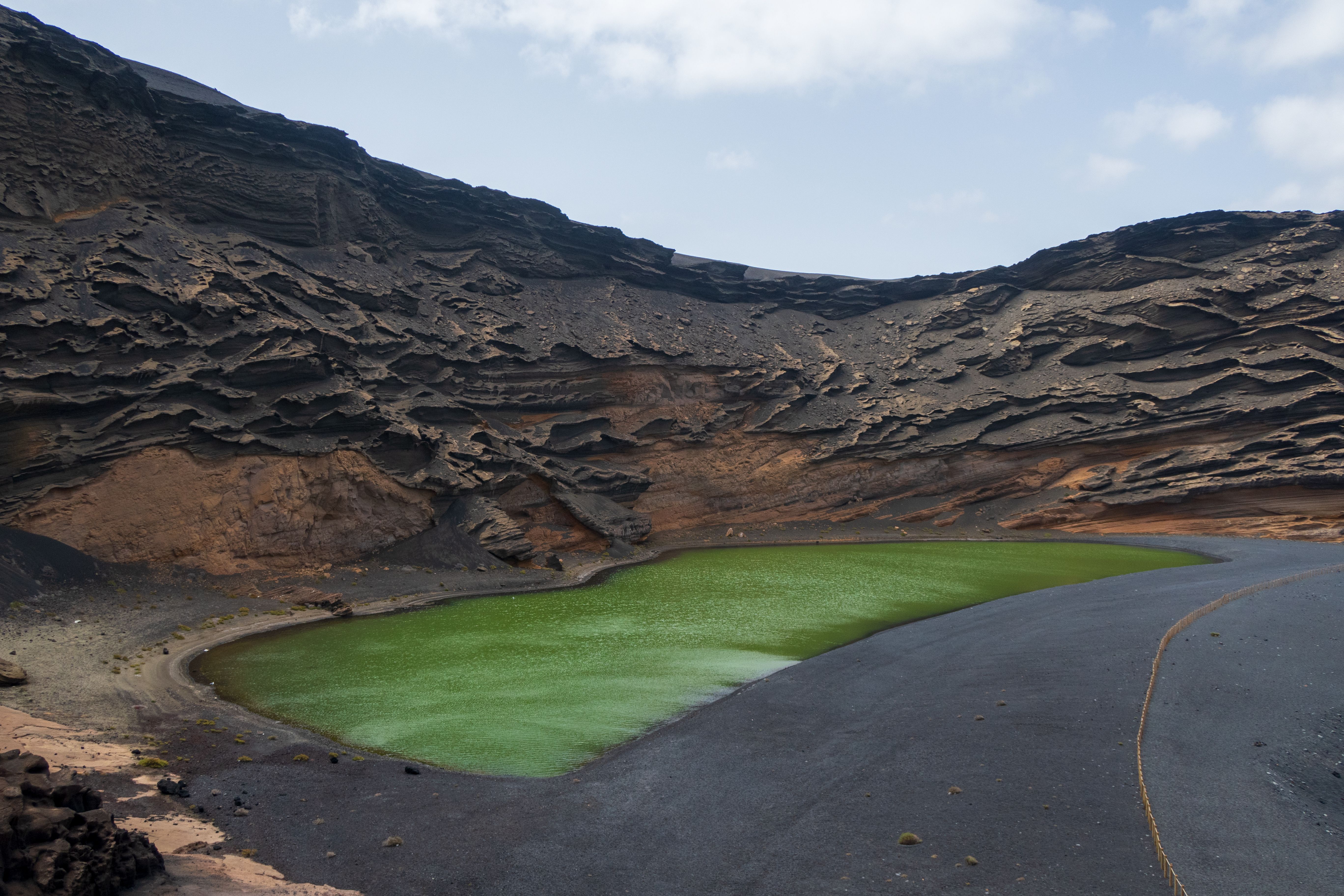 Volcanic terrain with a green crater lake in Lanzarote