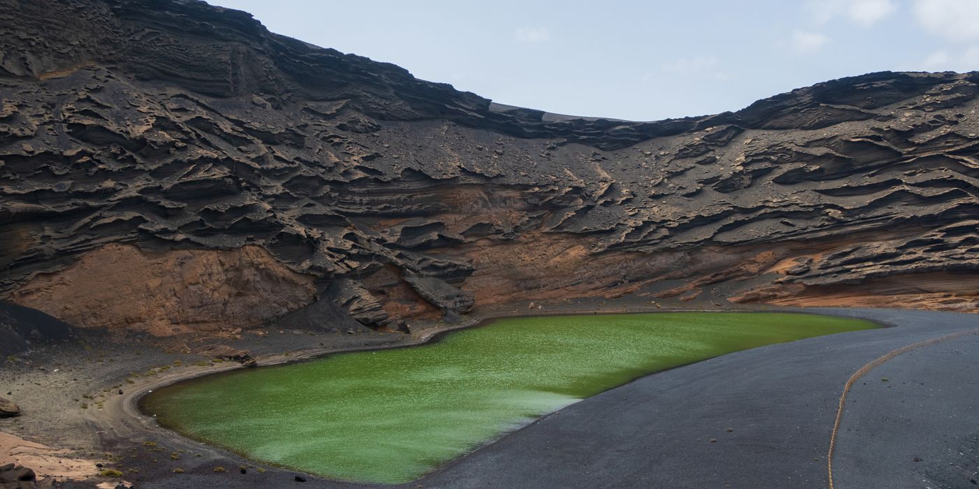 Volcanic terrain with a green crater lake in Lanzarote