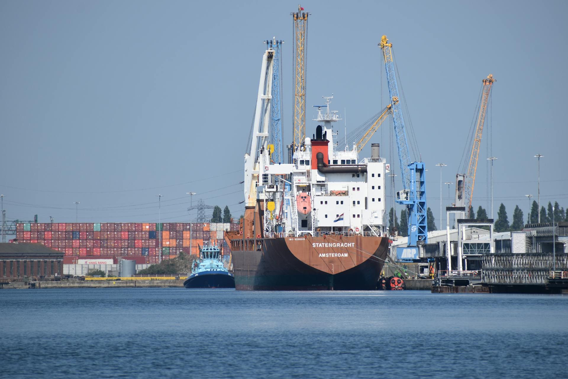 A cargo ship docked at Southampton harbor with cranes and shipping containers.