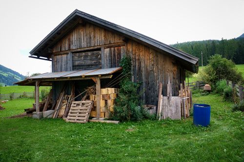Free A rustic wooden hut surrounded by lush greenery in the tranquil countryside of Innichen, Italy. Stock Photo
