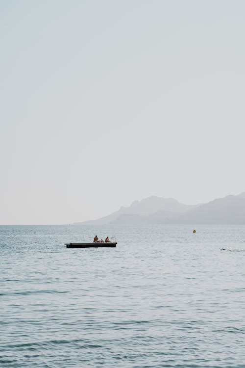 A man is in a small boat in the ocean