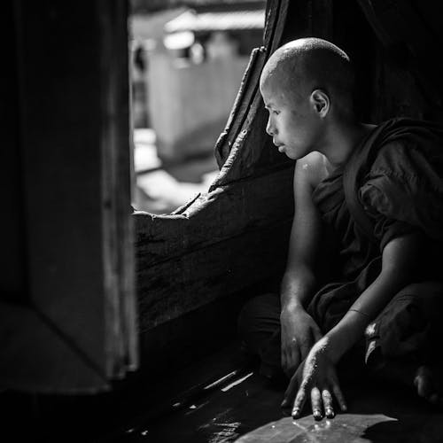 Young Boy in Monk Gown Sitting by Window