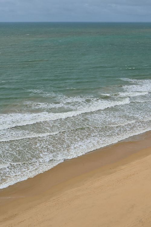 Free Calm ocean waves gently lap the sandy shore of Albufeira, Portugal's scenic coastline. Stock Photo