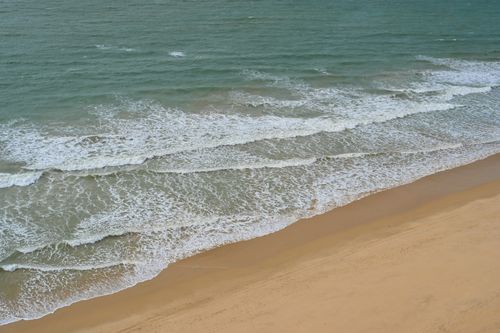 Free A tranquil view of waves meeting the sandy beach in Albufeira, Portugal. Stock Photo