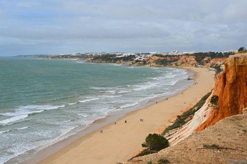 Free Beautiful aerial view of Albufeira's coastline with unique red cliffs and azure sea waves. Stock Photo