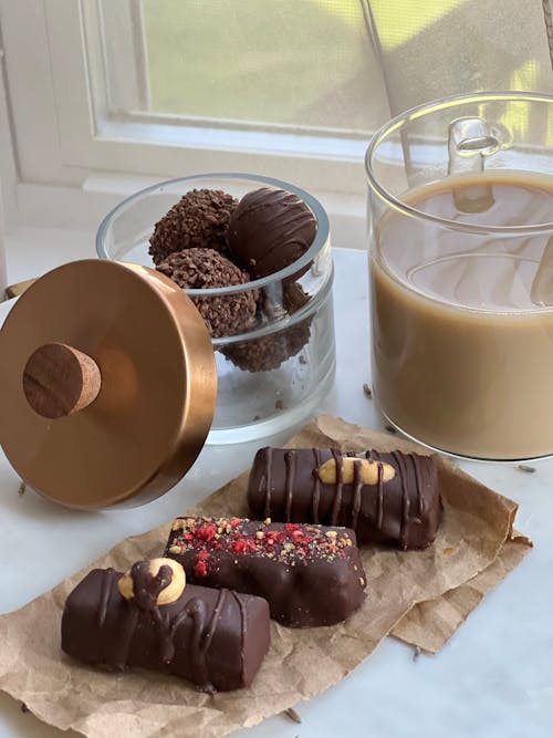 A cup of coffee and chocolate covered treats