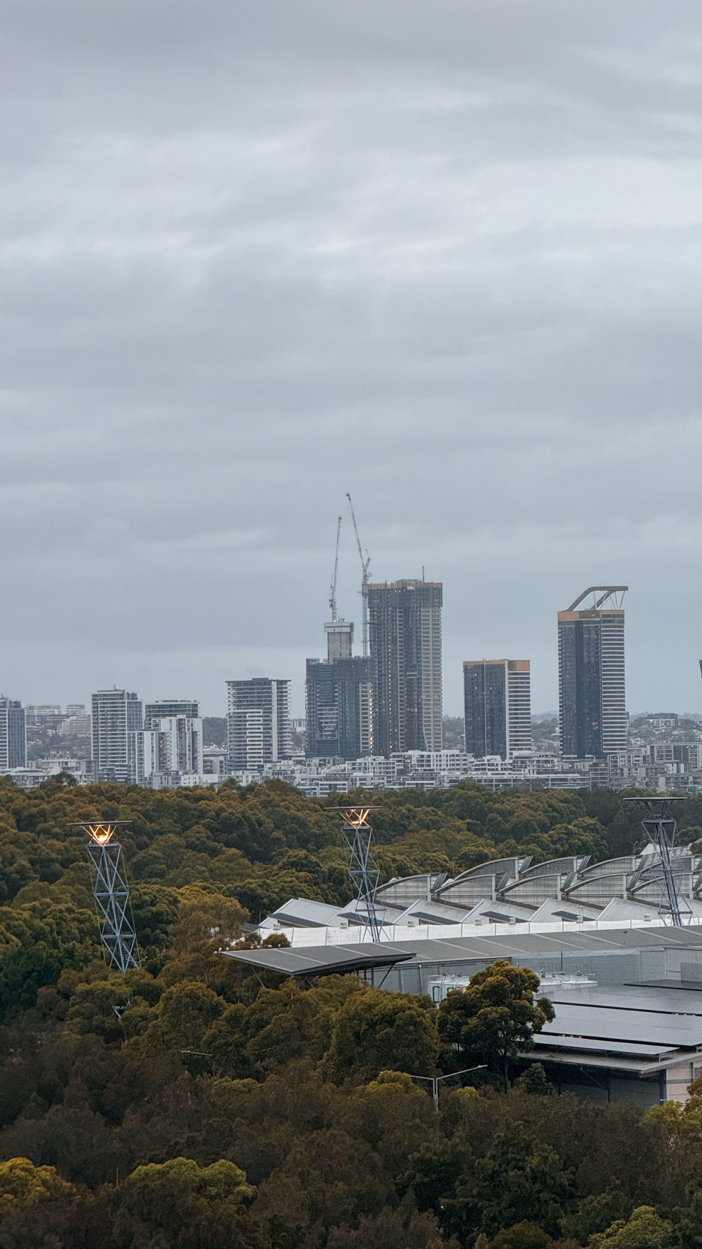 Skyline view of Parramatta, Australia, featuring modern buildings under an overcast sky.