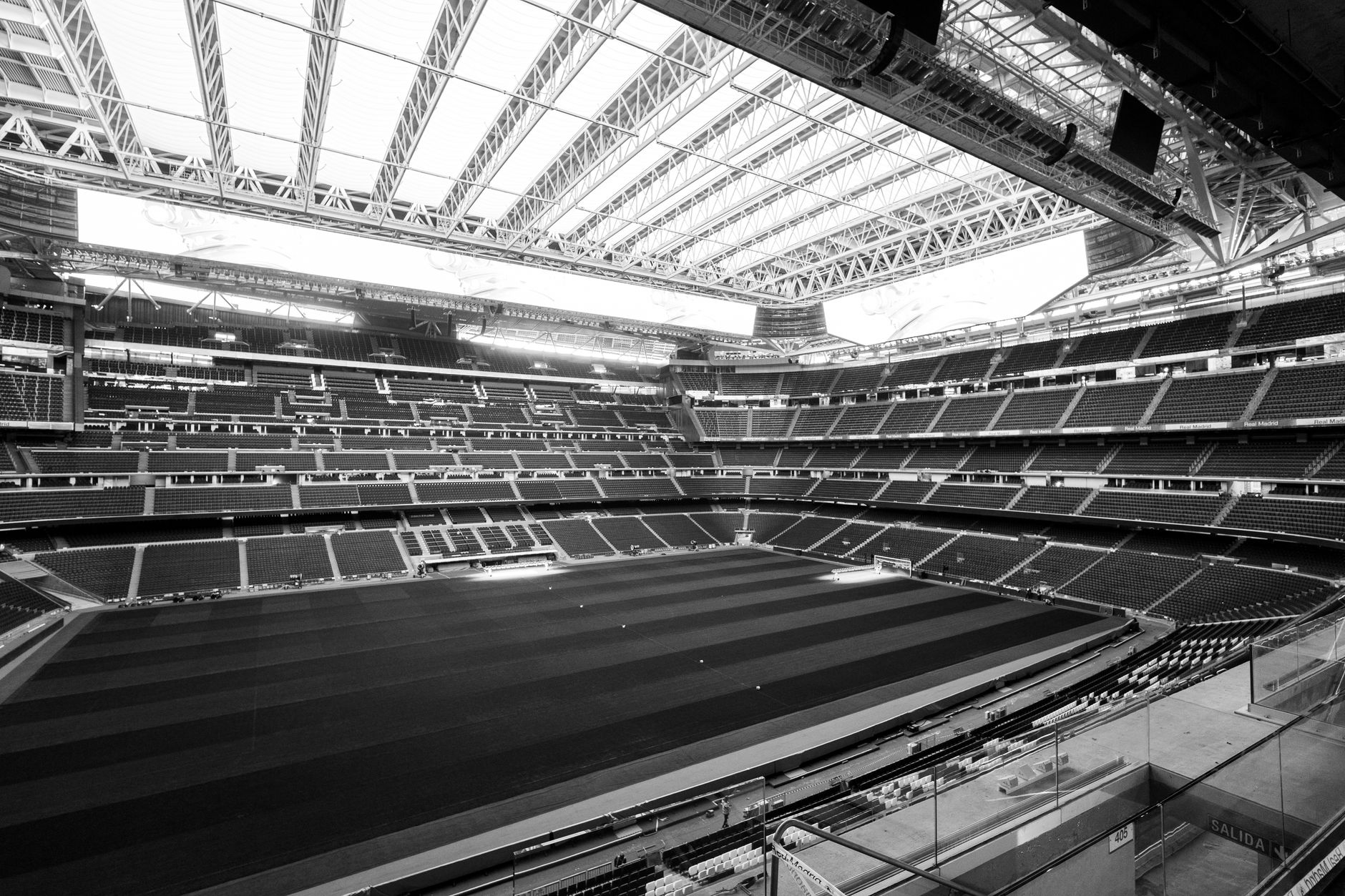 Black and white photograph of a large stadium with retractable roof in Madrid, Spain.