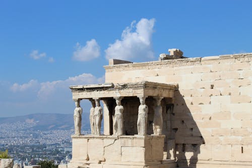 Ancient Building with Columns in Front of a Landscape of a City and Mountains in Athens, Greece