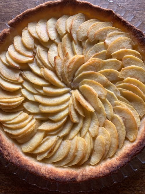 Free A top view of a homemade apple tart with golden brown crust and thinly sliced apples. Stock Photo
