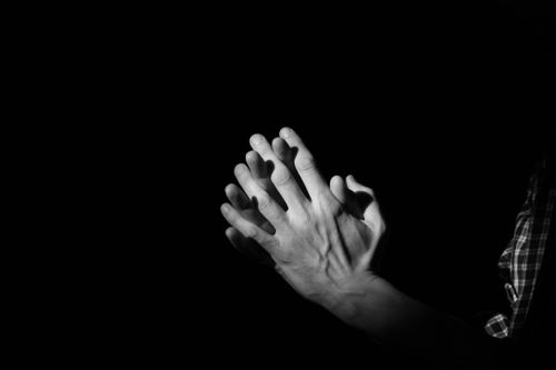 Free A dramatic black and white photo showing hands clasped in prayer, symbolizing faith and devotion. Stock Photo
