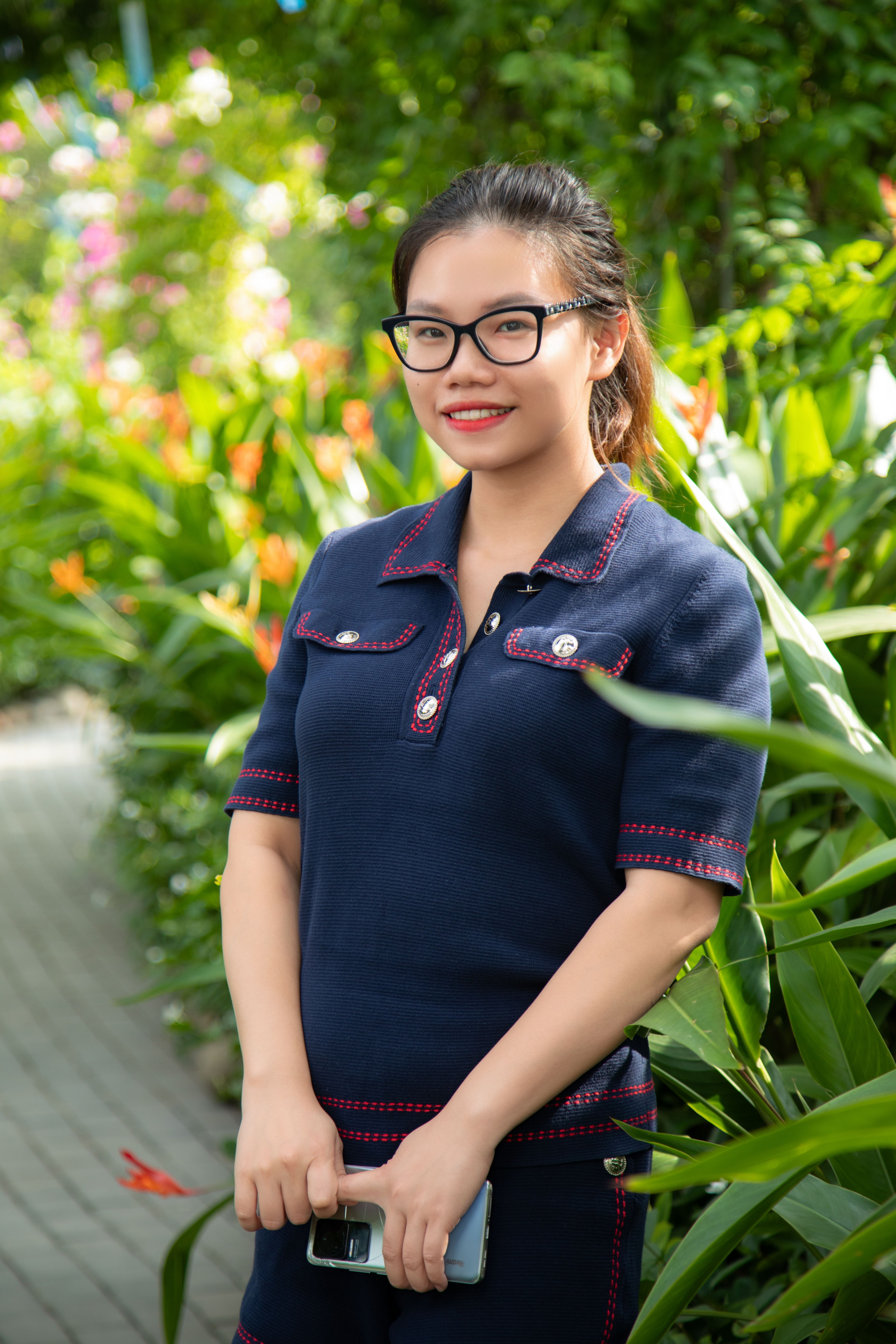 A stylish young woman poses in a beautiful garden in Hà Nội, Vietnam.