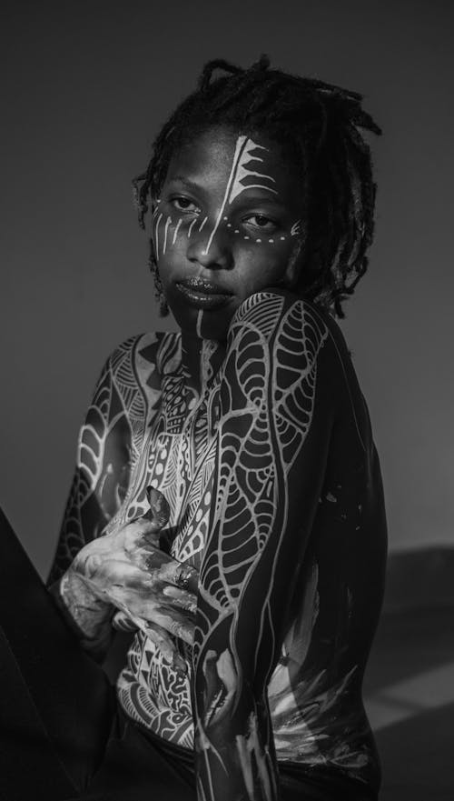 A black and white photo of a woman with body paint