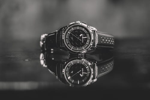 A black and white photo of a watch on a table
