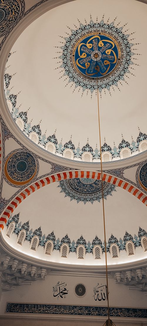 Free Beautifully ornamented mosque dome featuring Islamic calligraphy and intricate designs. Stock Photo