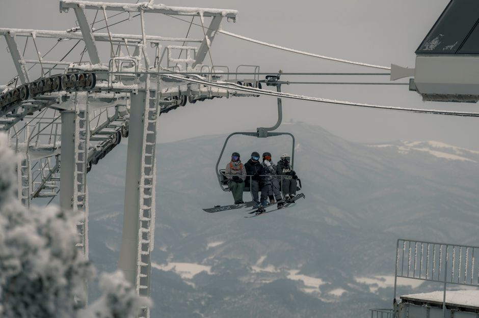 A group of skiers on a snow-covered chairlift, enjoying a winter ski trip in the mountains.