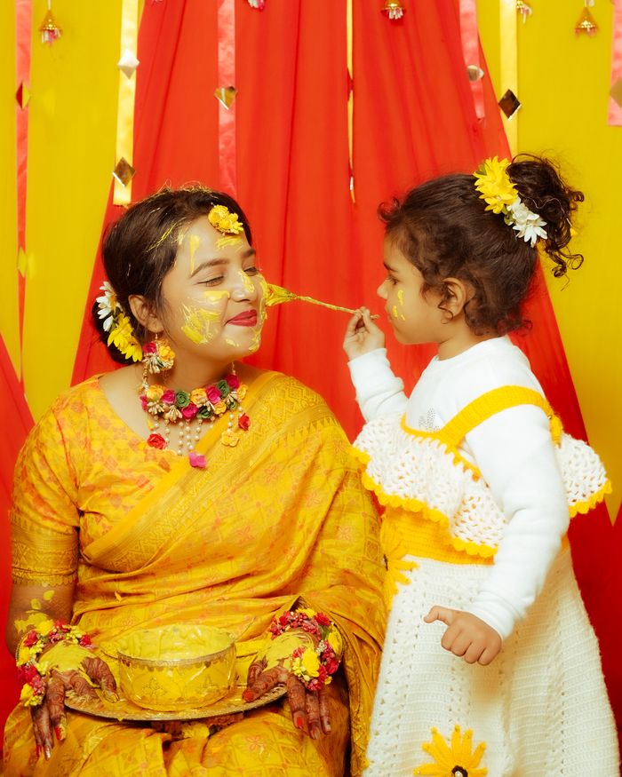 Child applying haldi to the bride