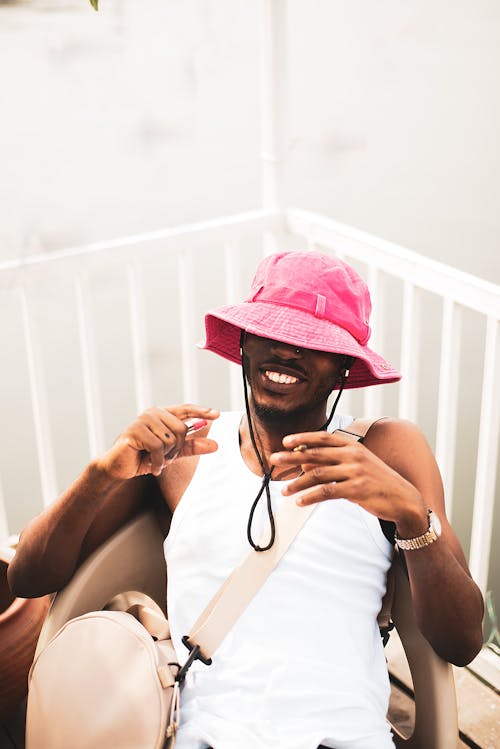 Smiling Man in Hat Sitting on Chair