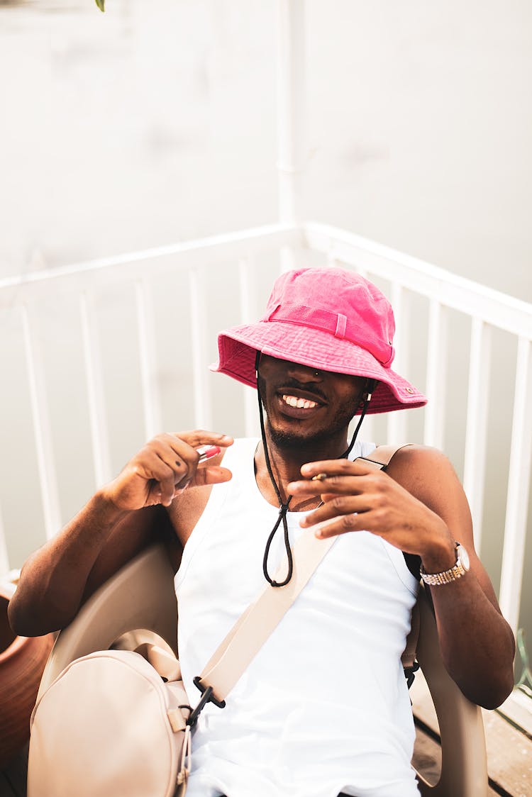 Smiling Man In Hat Sitting On Chair