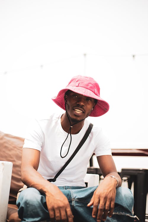 Young Man in a Pink Hat Sitting Casually