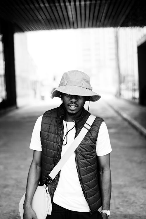 Black and White Photo of a Man Wearing a Hat 