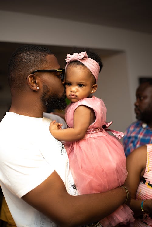 A man holding a baby in his arms while another man holds a baby