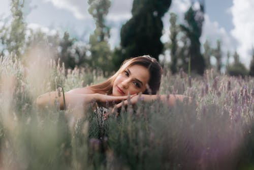 Young Beautiful Brunette Woman Laying Down in a Lavender Field