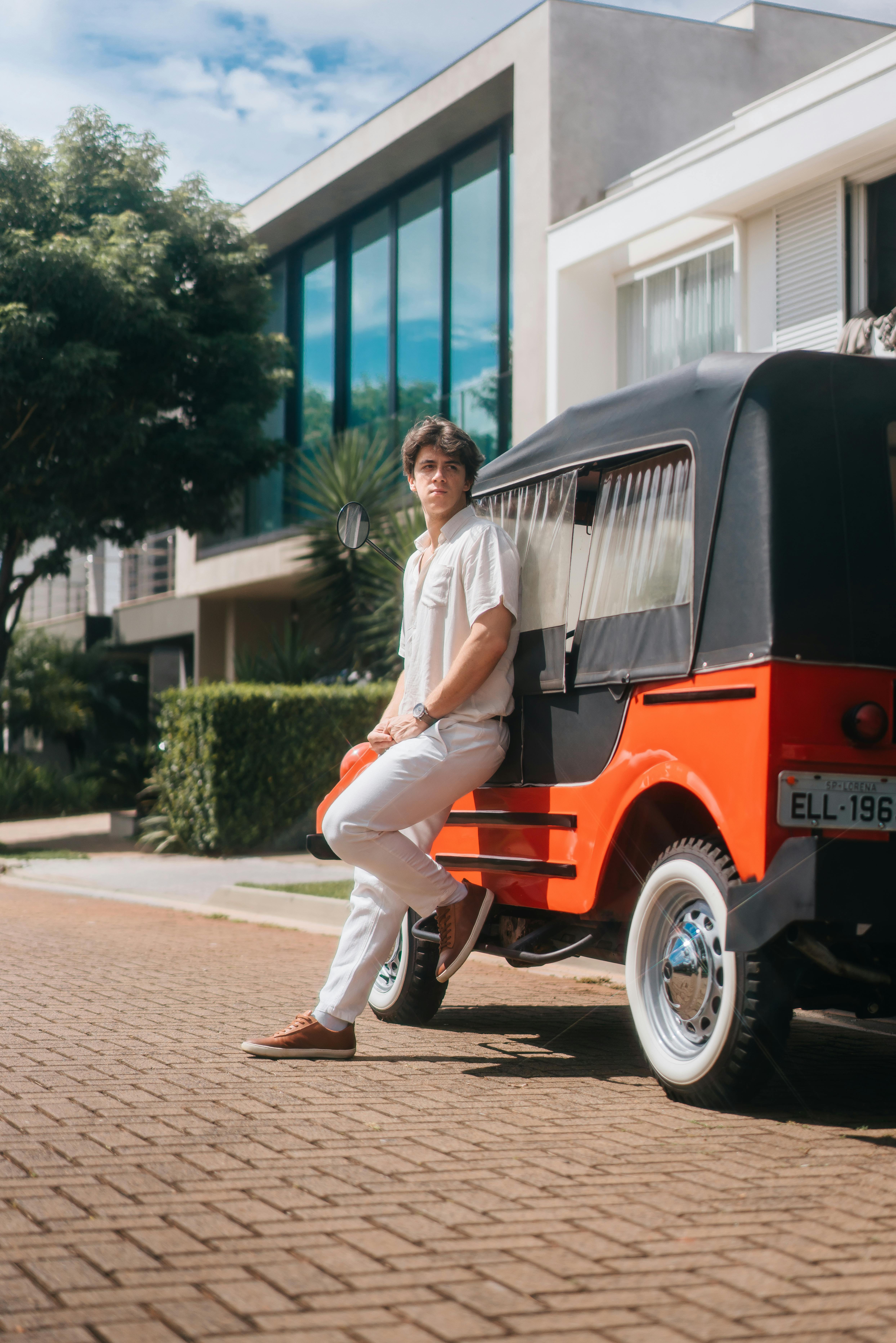 Free Young man posing with a unique retro vehicle on a sunny street in Maringá, Brazil. Stock Photo
