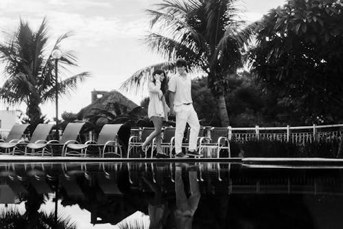 A couple standing on the edge of a pool