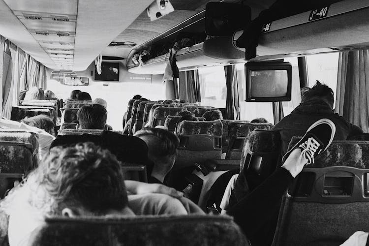 Grayscale Photo Of People On A Bus