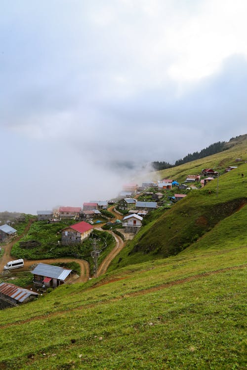 A small village on a hillside with fog