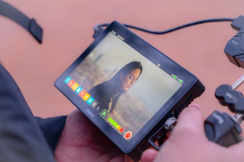 A person holding a small tablet with a camera