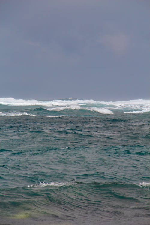 A person standing on a surfboard in the ocean