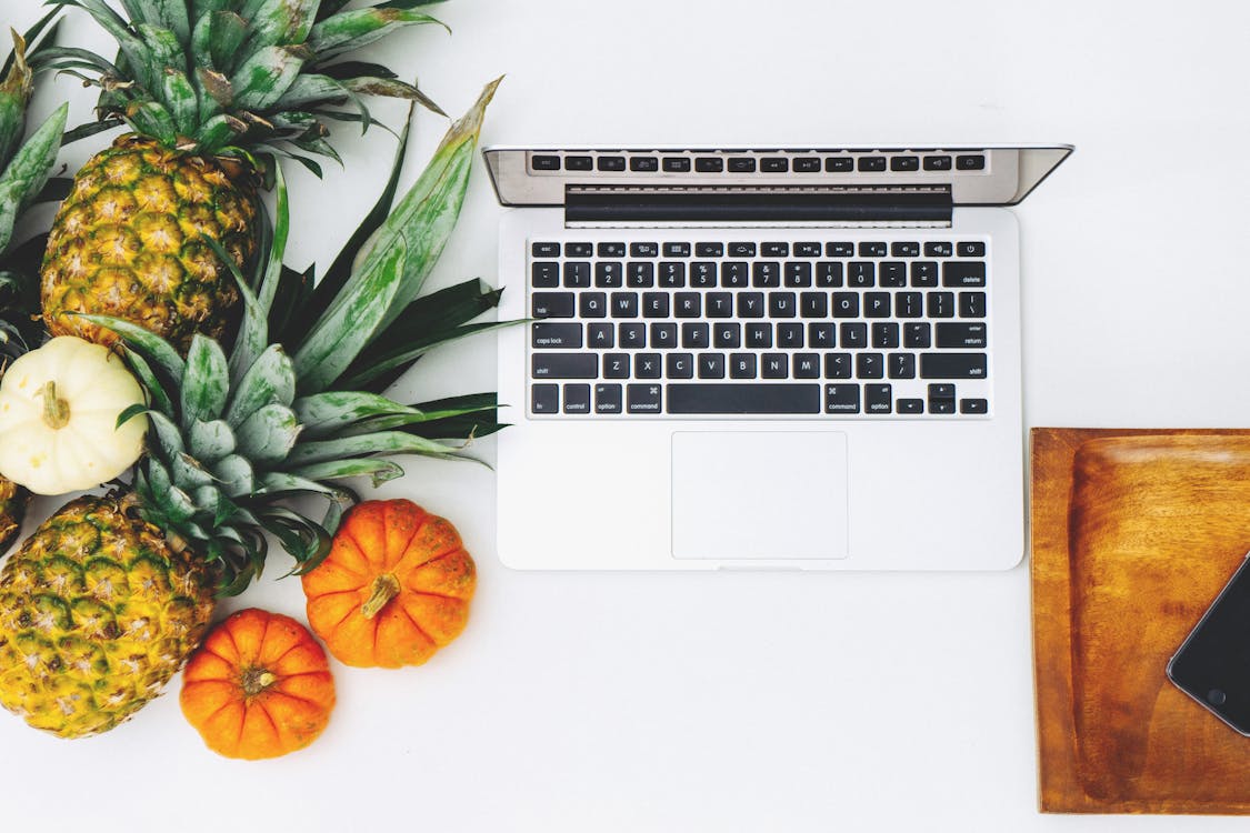 Macbook Blanco Cerca De Piña Y Calabaza