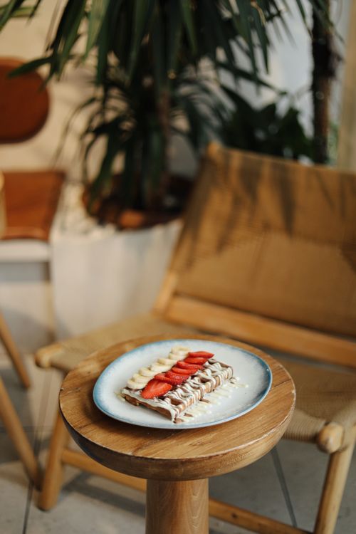 Free A delicious waffle topped with fresh strawberries served on a rustic wooden table. Stock Photo